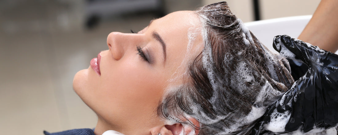 woman with dark hair having her hair washed